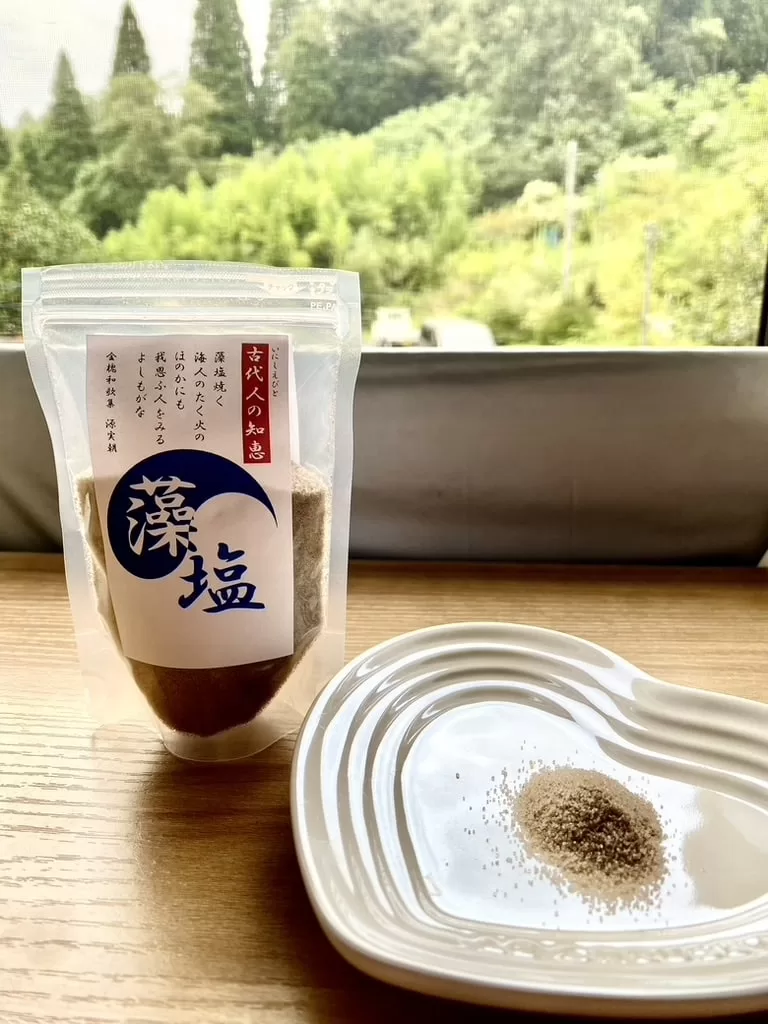 Japanese moshio seaweed salt in a small dish beside its package